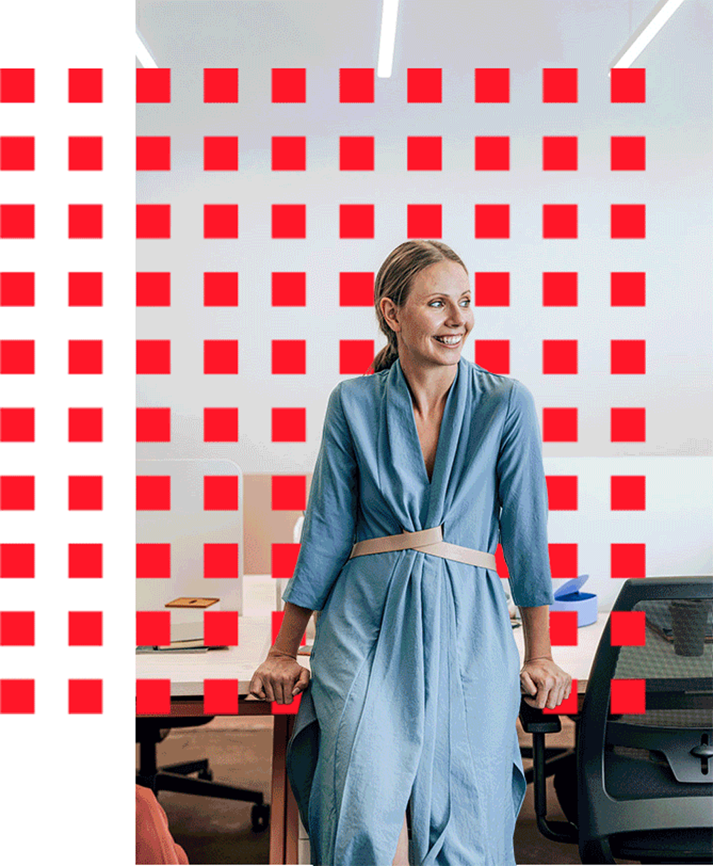 Workplace scene: woman smiling at table with red squares.