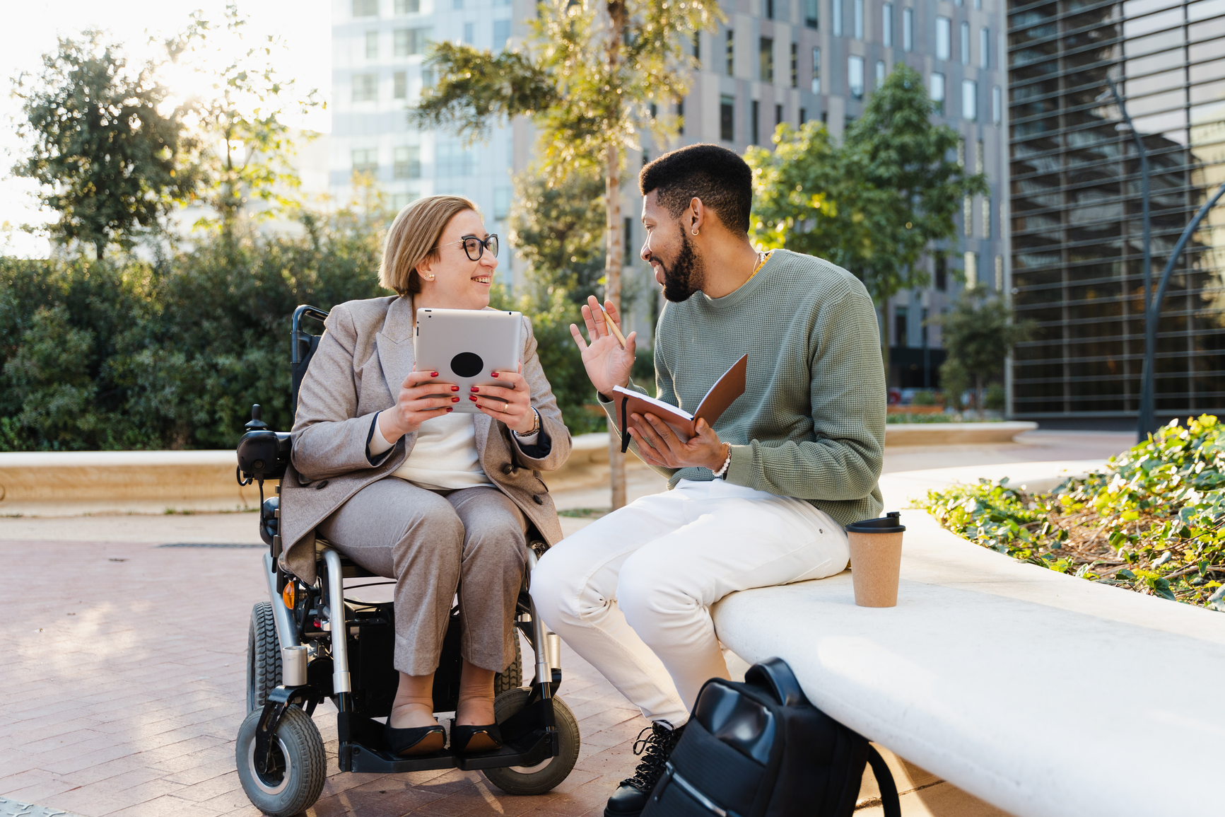 Woman in a wheelchair speaking with seated Black man