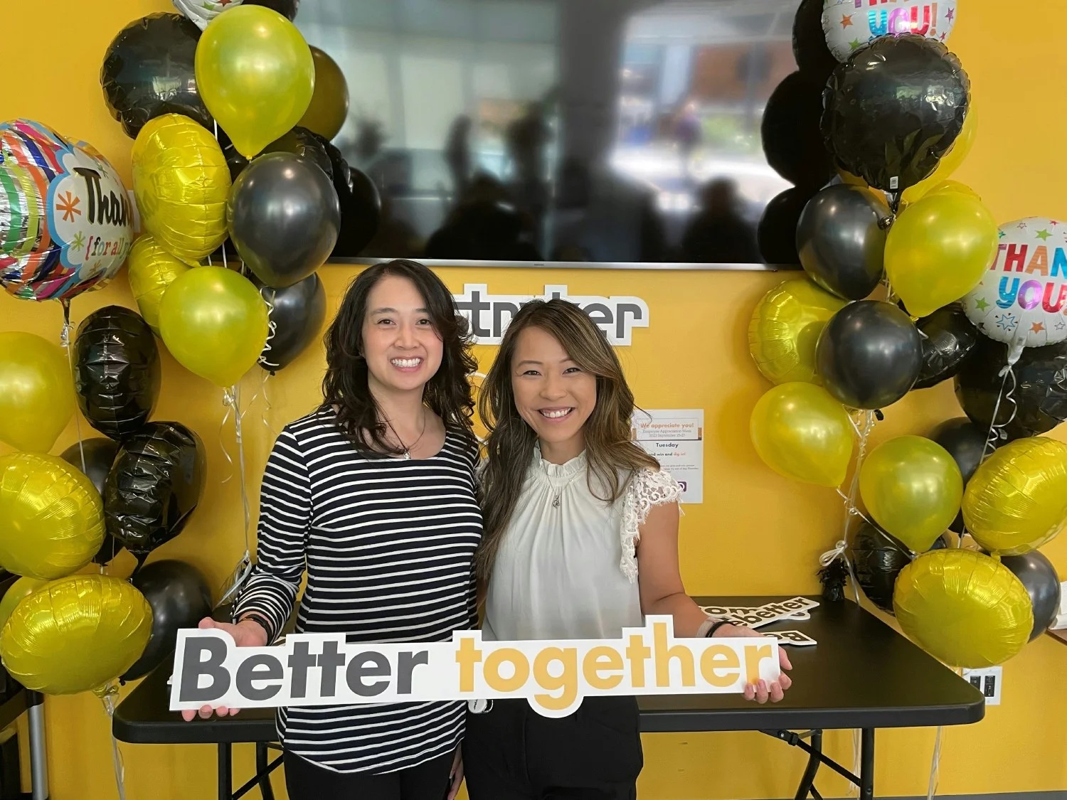  Two women workers holding up a Better Together sign at Stryker 