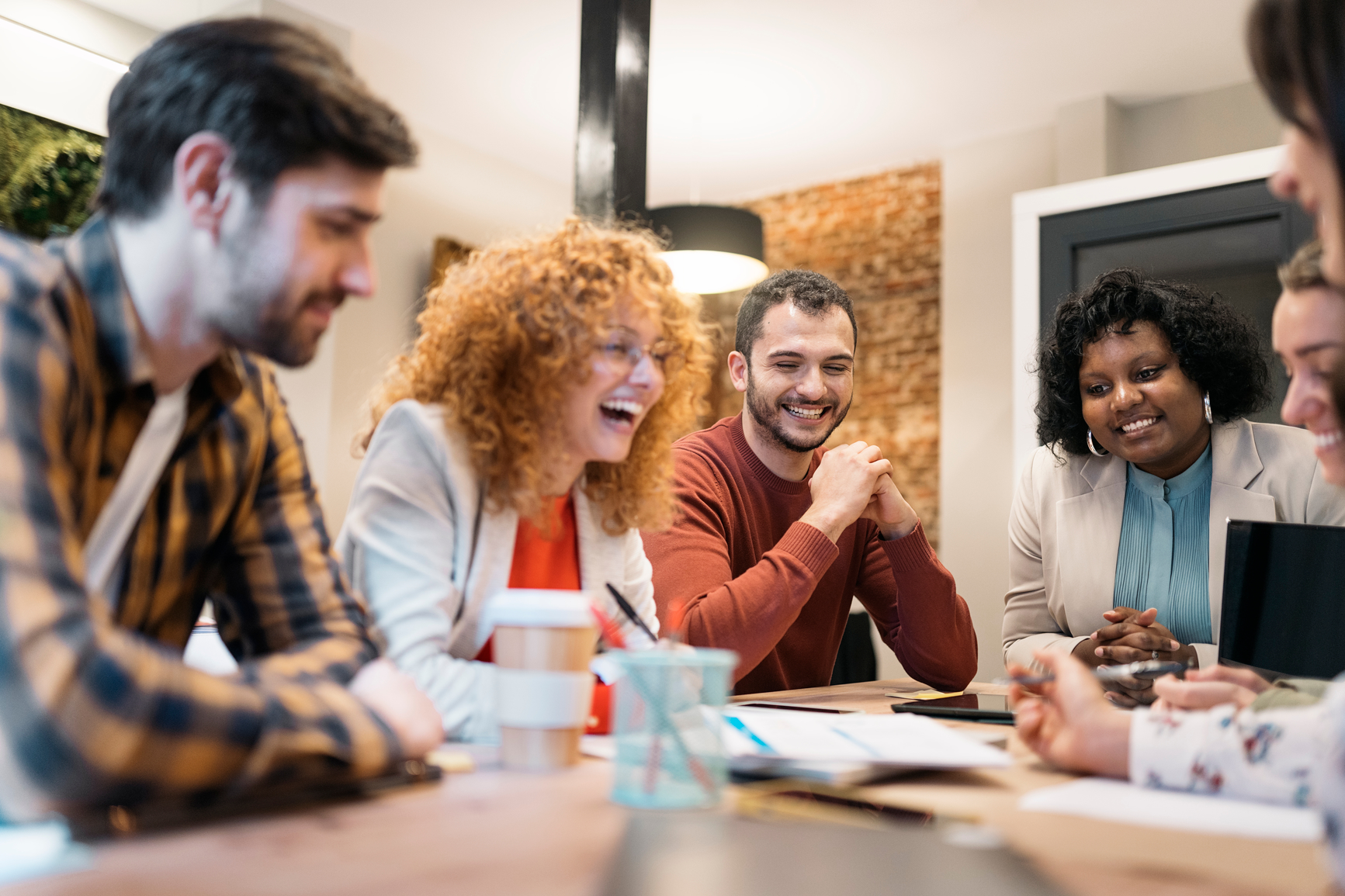  six smiling employee collaborate across a table