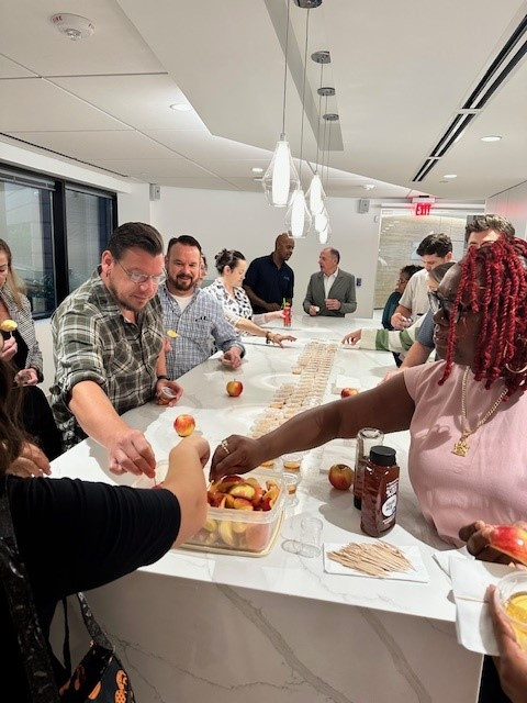 Our team comes together to dip apples in honey, wishing everyone a year filled with joy, health, and prosperity. 