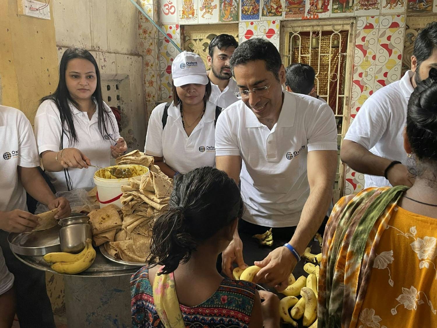 Oxford International team members volunteering at a community food drive in India. 