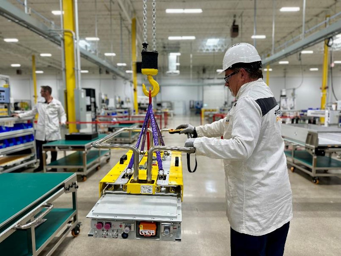 The maintenance lead is moving the battery on the production line. 