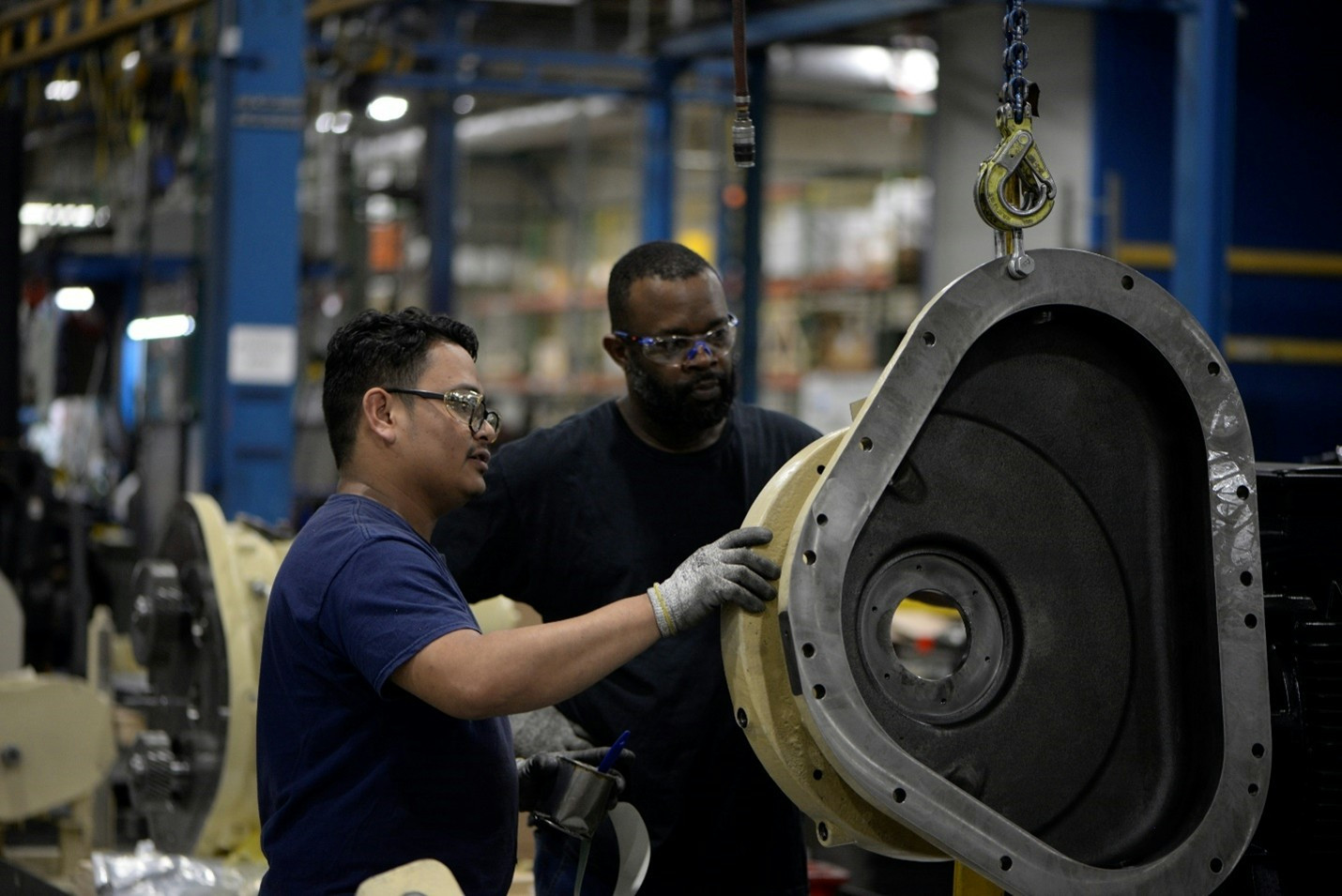 Two employees examine a piece of equipment at an Ingersoll Rand facility. 