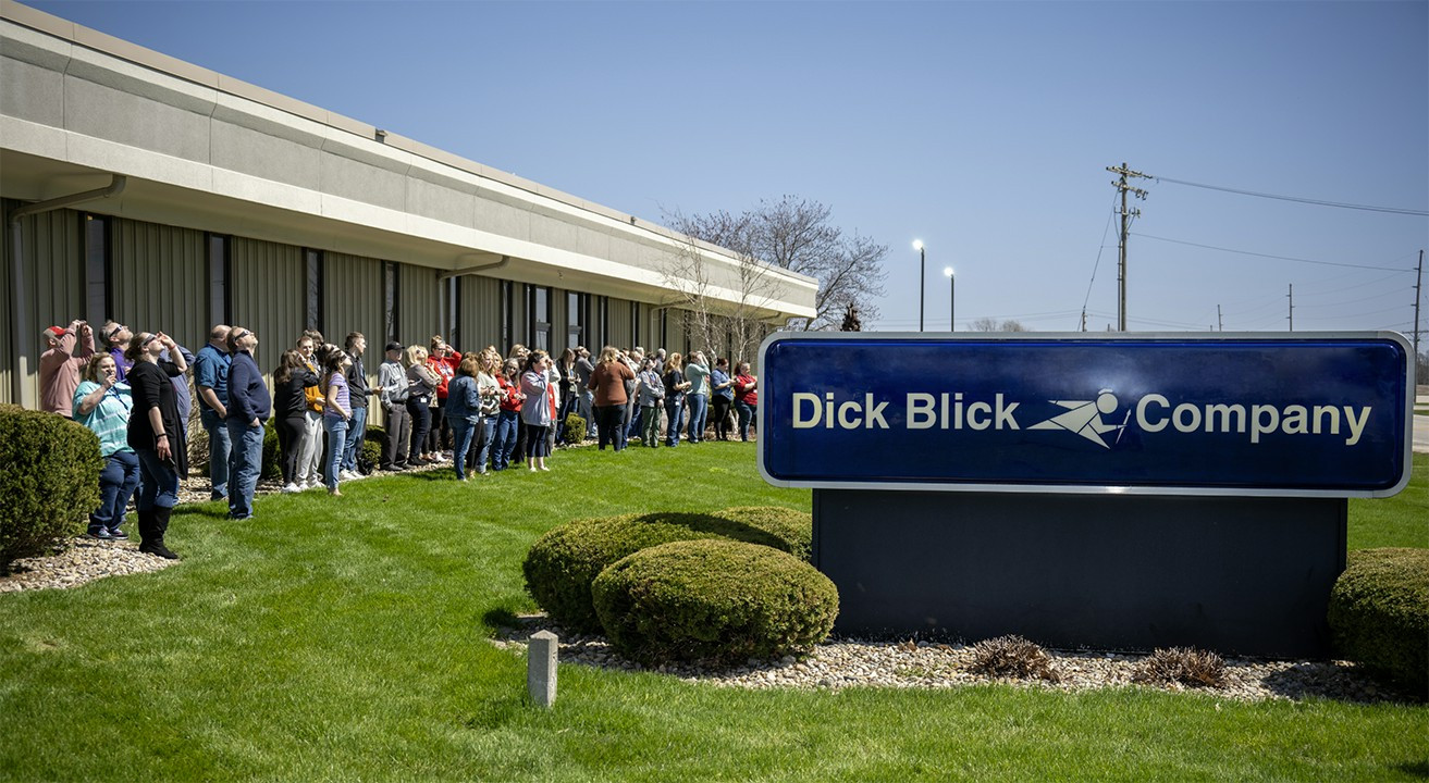 Associates anxiously await the 2024 solar eclipse while gazing to the sky with their Blick provided solar glasses