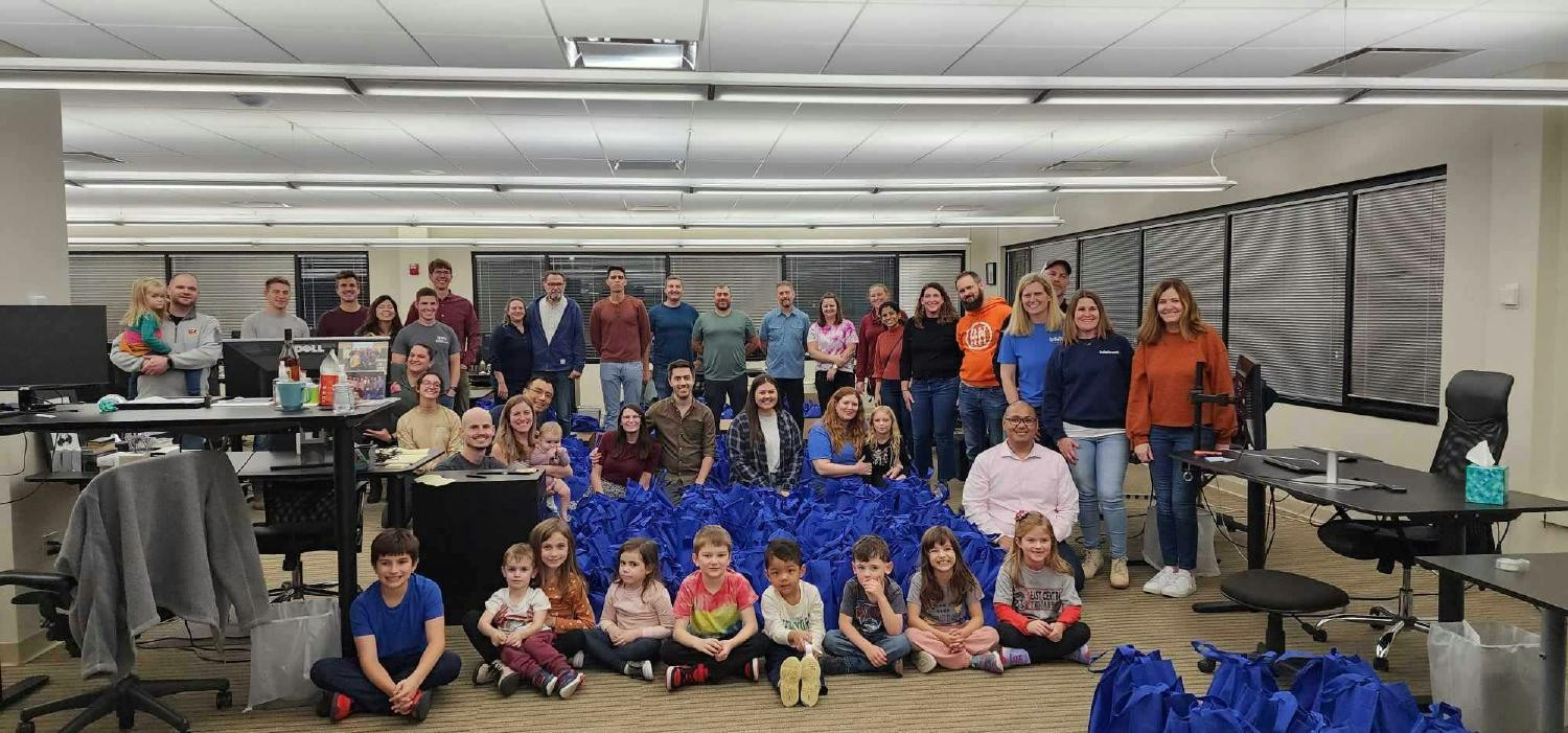 A large photo of IntoTrust team members and their families at our annual Basket Brigade volunteering event.