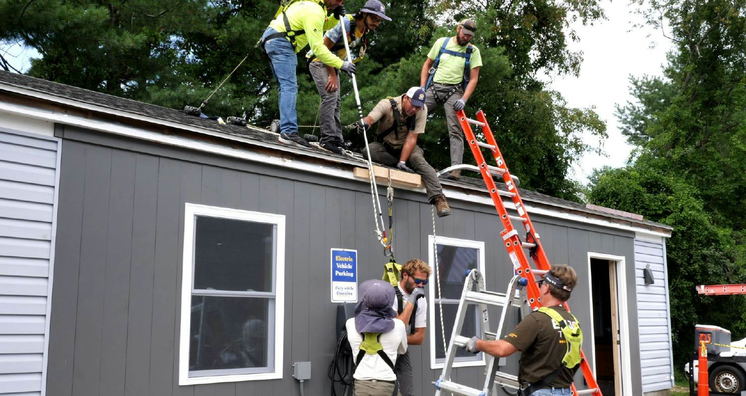 Co-Owners work together at our South Portland office at a harness safety training.  