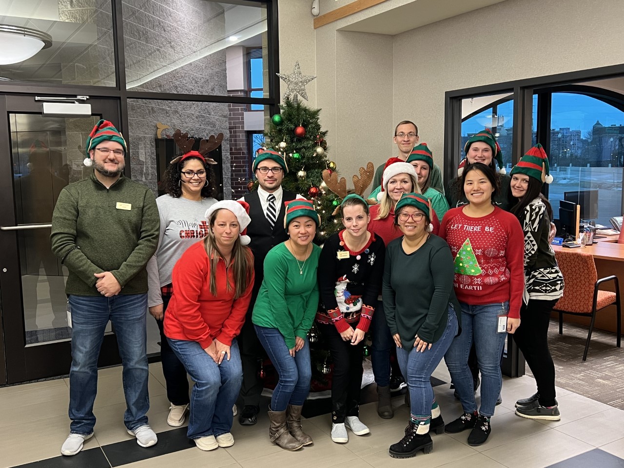 Staff posing for a holiday photo donning their festive attire.