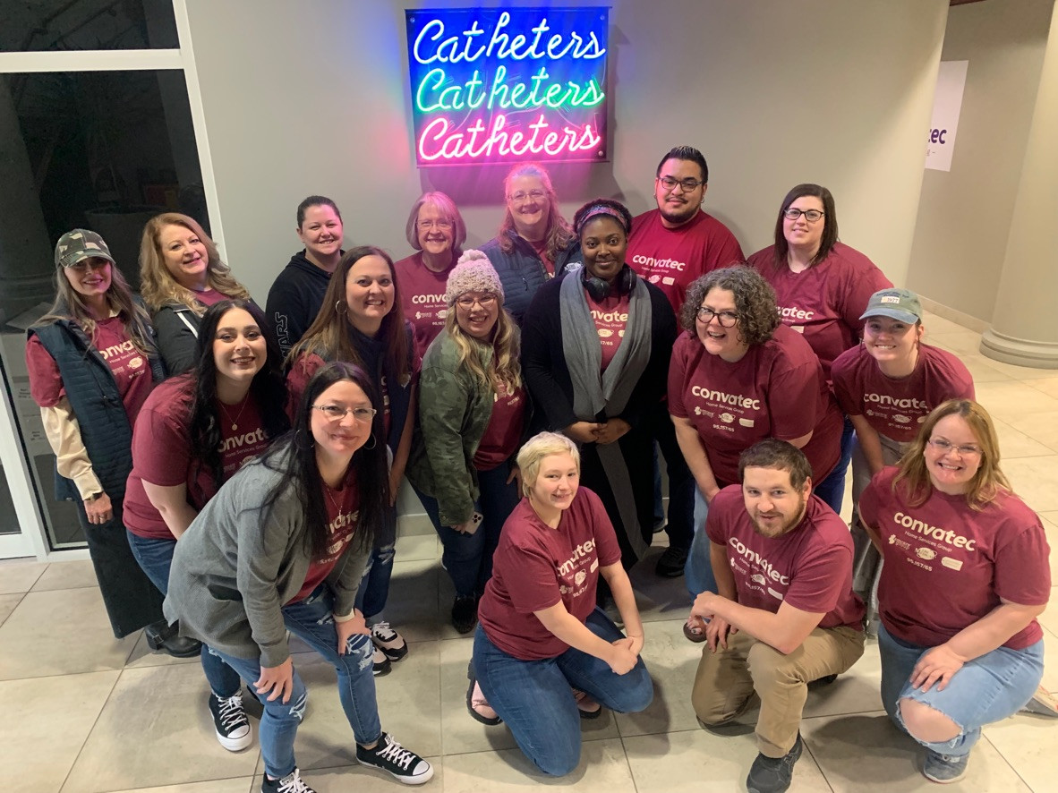 We're in the catheter business! A team poses with the new neon sign. 