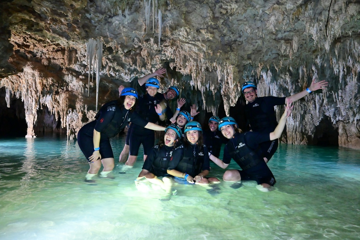 Part of the company exploring a cave as a team outing.