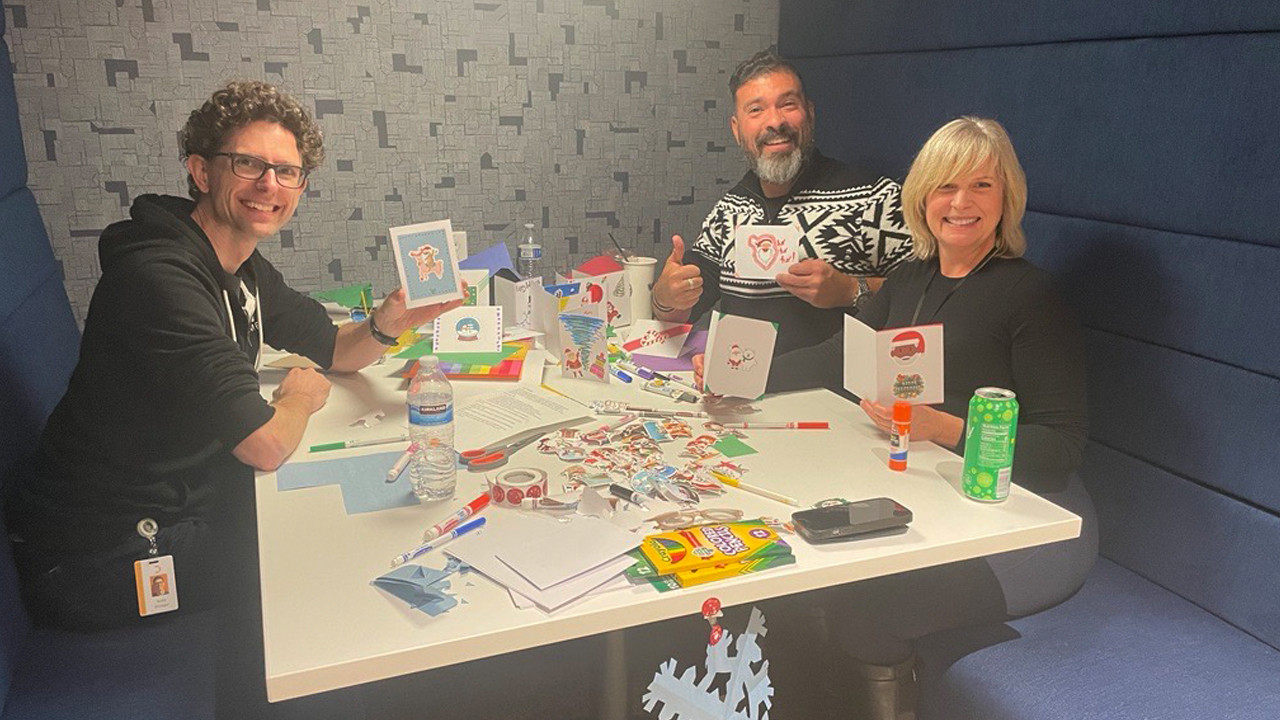 Employees decorate holiday cards for seniors as part of Datasite’s end-of-year in-office celebrations. 