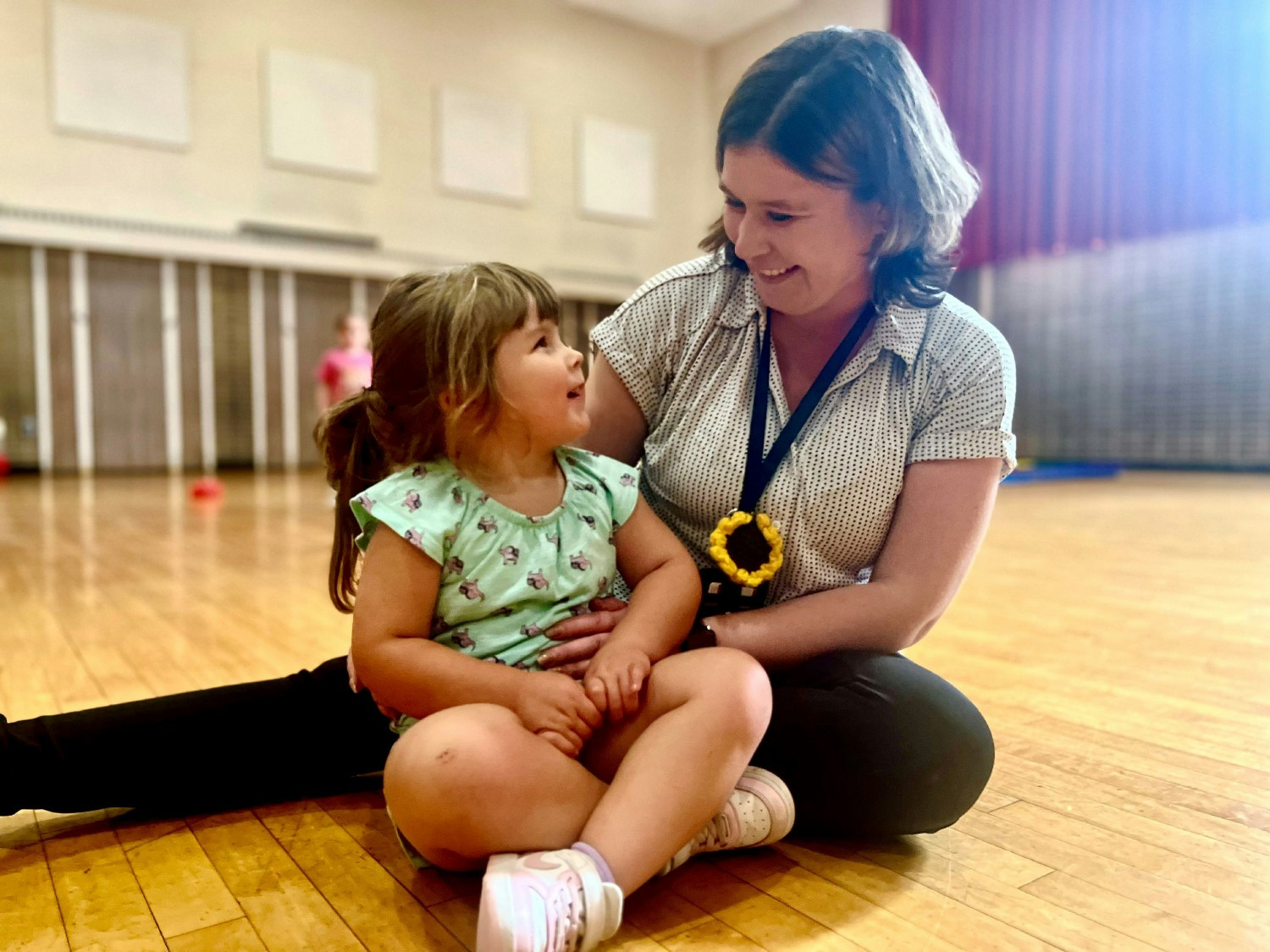 Berkshire County Head Start Teacher, Valentyna Gagnon, sits with a student during recreation time.