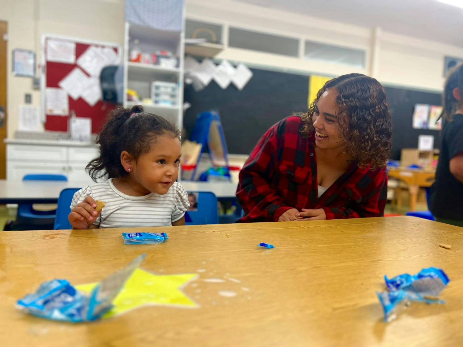 Berkshire County Head Start Teacher Assistant,Brittny Dewitt sits with a child at snack time.