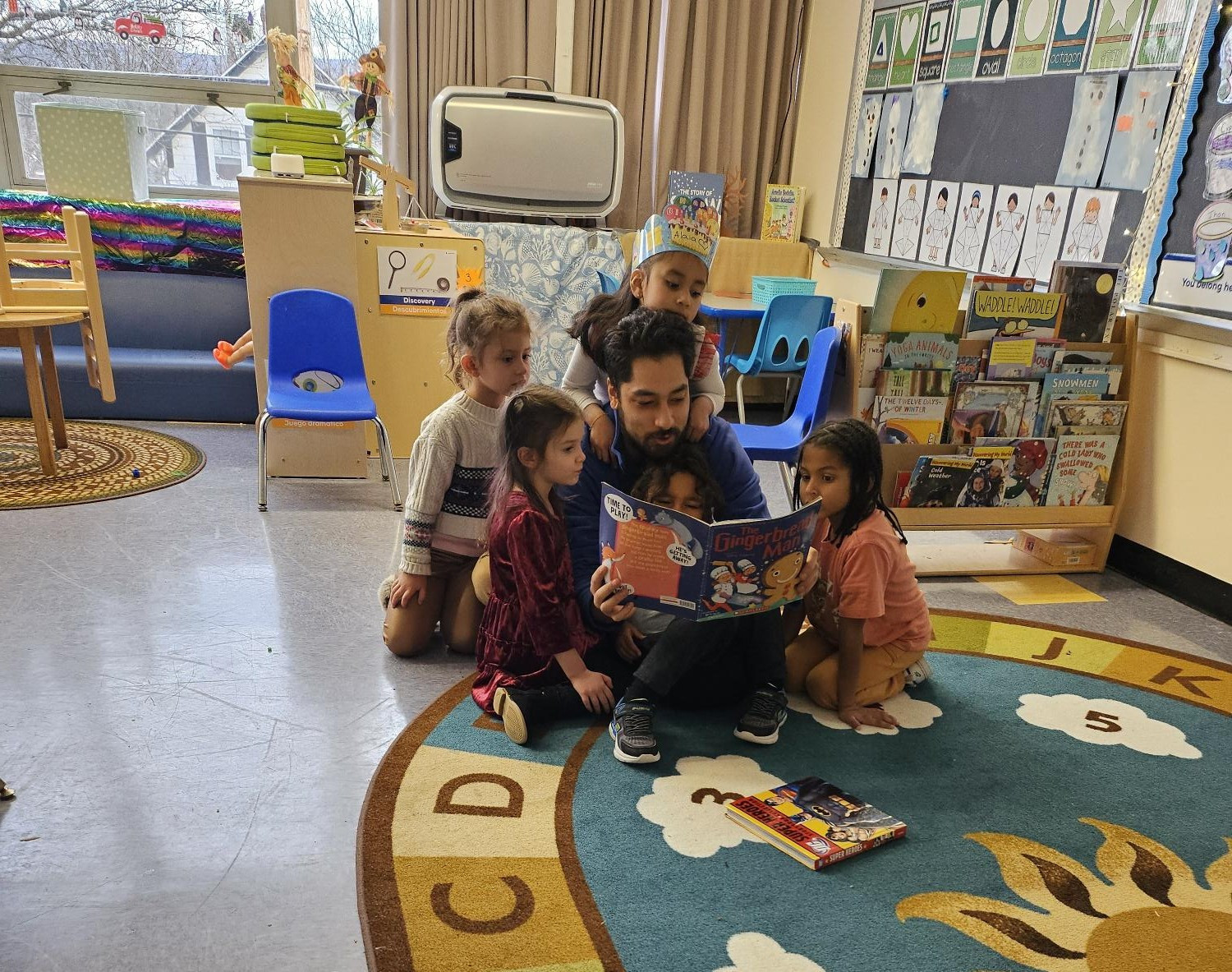 Berkshire County Head Start Teacher Assistant, Giovanni Figueroa, reads to children at circle time.