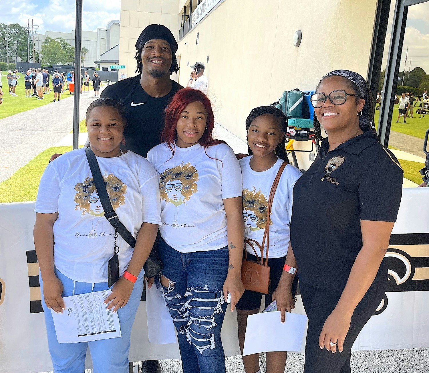 Our Operation Girls participants and our CEO Syrita  Steib pose with New Orleans Saints player Jameis Winston 