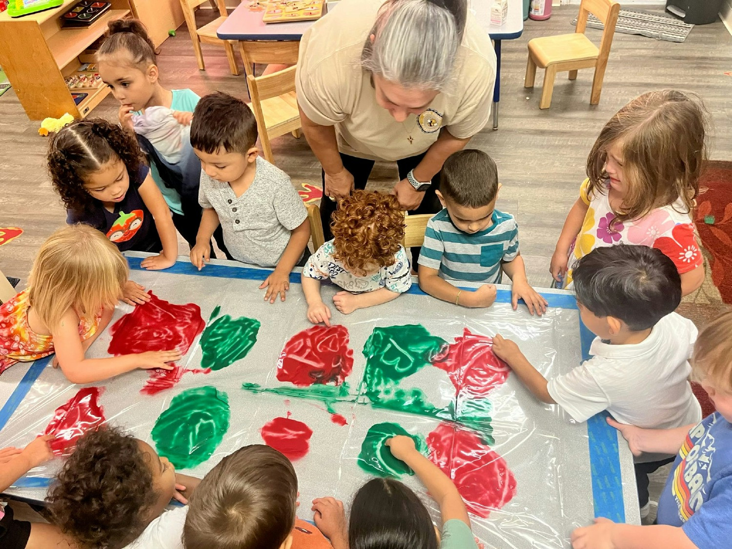 Creative play: Little artists explore colors and shapes, fostering teamwork and sensory learning at our preschool.