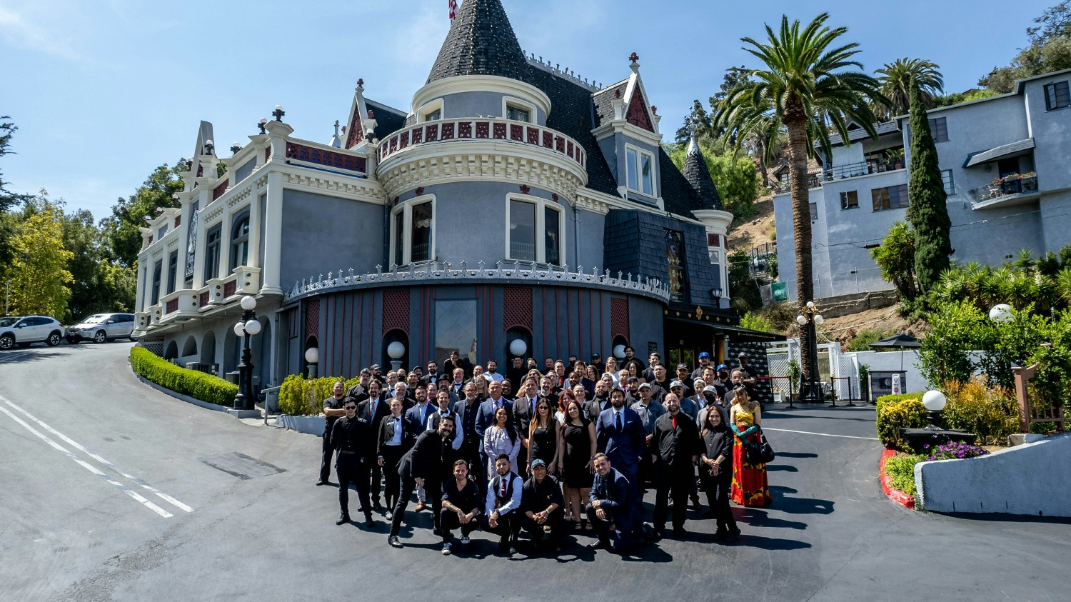 Our incredible team gathers in front of the iconic Magic Castle, where we bring magic to life every day for our members 