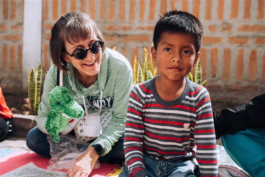 Employee Nancy P. entertains a waiting child on recent medical mission to Ecuador, 1 of 4 ongoing Godlan mission areas.