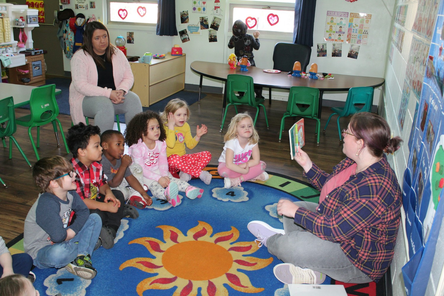 Teachers in the Early Childhood Learning Center reading to children in their classroom.