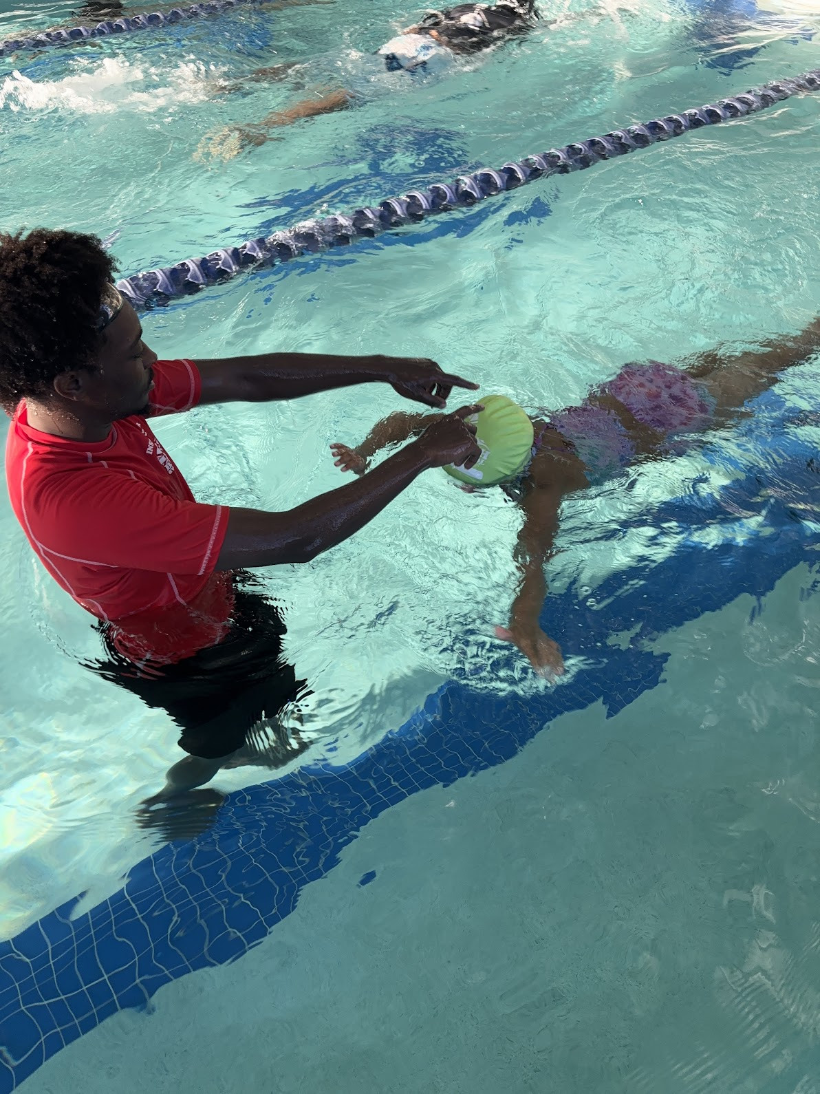 Mr. Anthony helping a student learn to swim