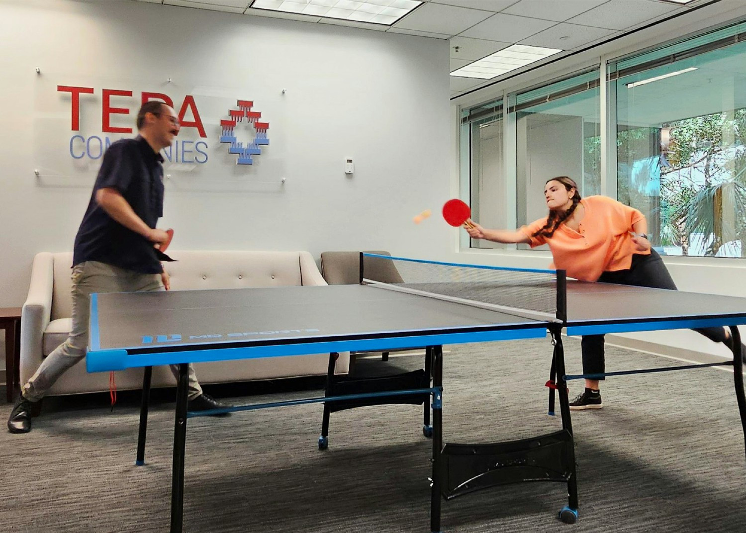 Two Tepa employees take a break from regular work to play ping pong in the Orlando office