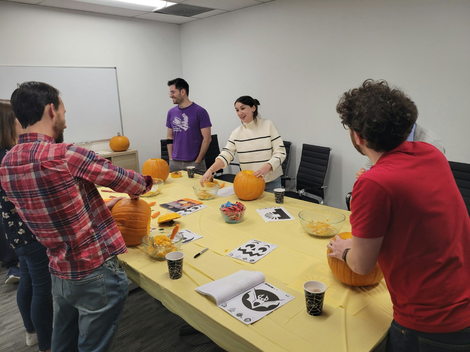 Team members getting creative and competitive during an October pumpkin carving event.