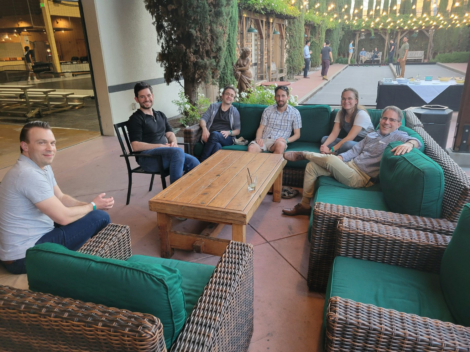 A group of teammates relaxing and bonding during a fun after-work Bocce Ball session.